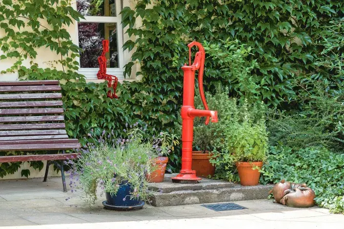 Ruční pumpa a rostliny vysázené v květináčích Ruční pumpa a rostliny vysázené v květináčích