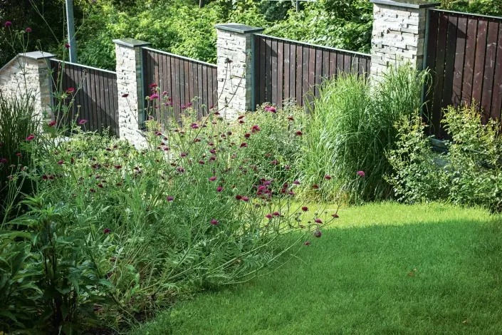 Zděný plot doplněný dřevěnými laťkami Zděný plot doplněný dřevěnými laťkami