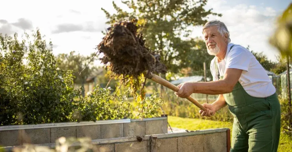 Zahrádkář přehazuje kompost
