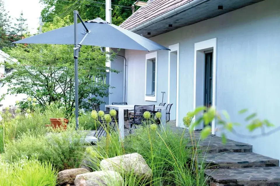 Sezení pod slunečníkem u domu