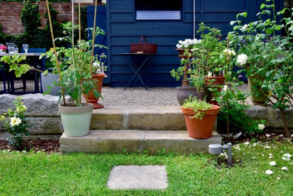 Štěrkové pódium s jídelním stolem a zahradním domkem