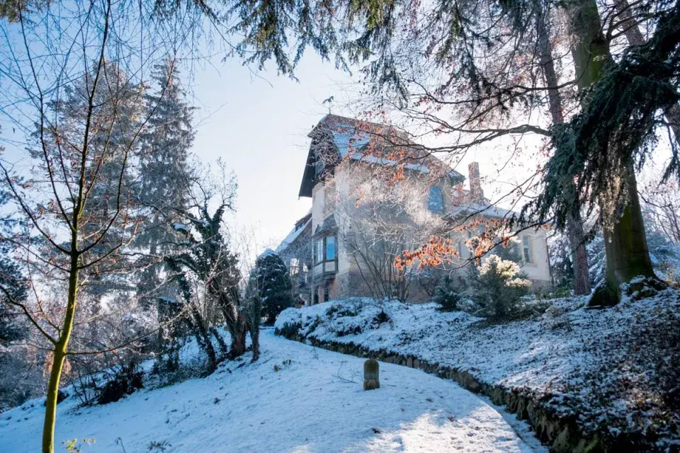 Zasněžená svažitá zahrada u secesní vily