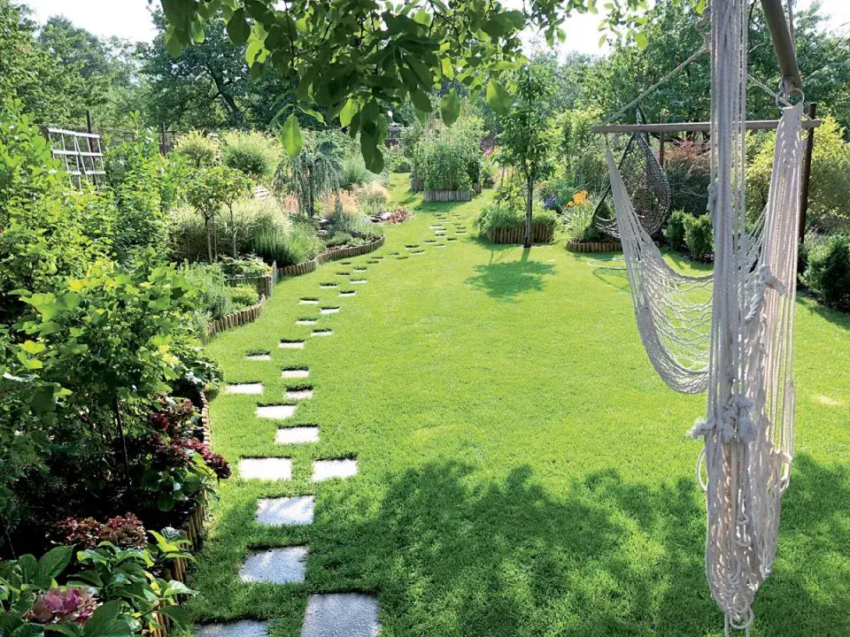 Trvalkové záhony a trávník s houpačkou