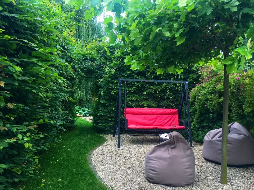 Houpačka a sedací vaky za živým plotem