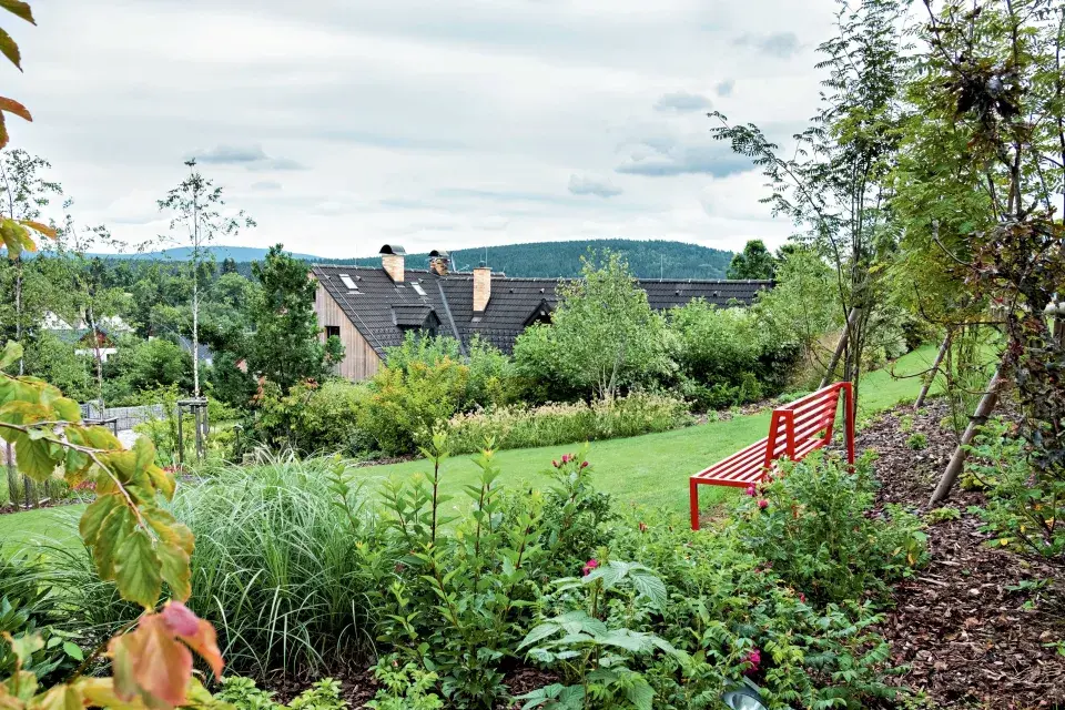 Červená lavička a výhled do zahrady