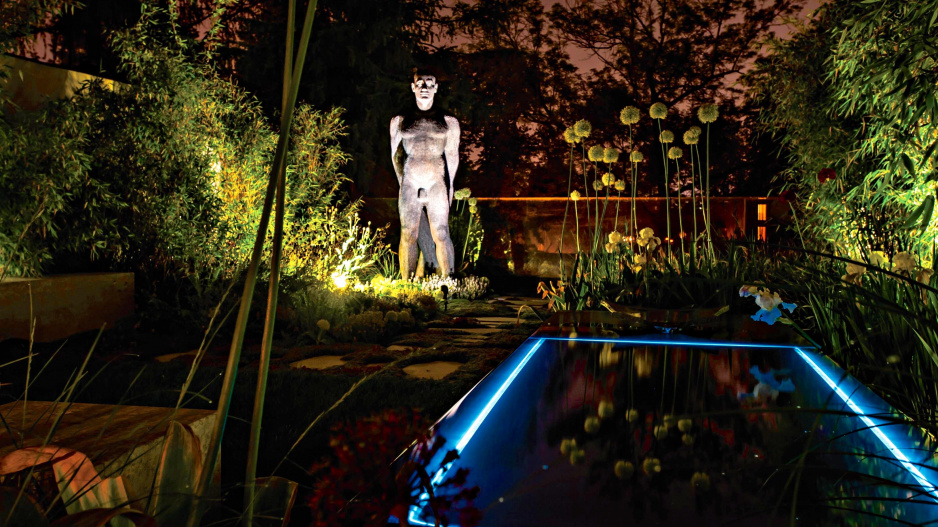 Osvětlený okraj bazénu a socha muže