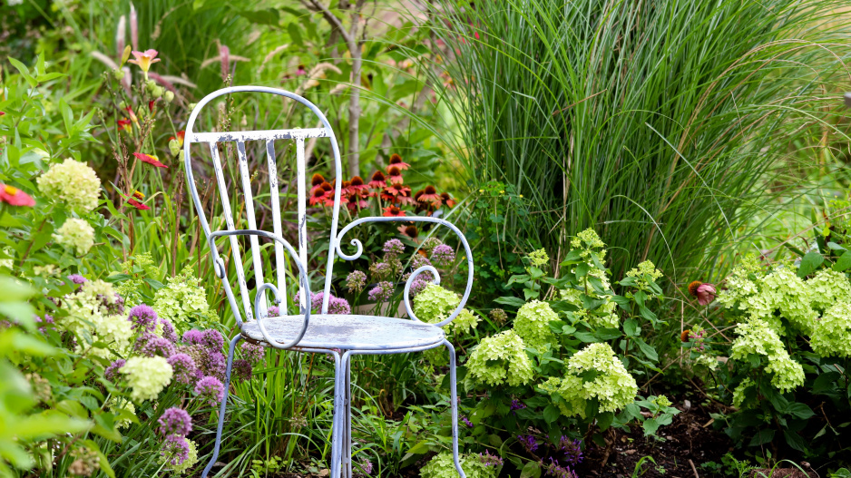 Kovová židle v rozkvetlé zahradě
