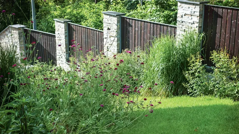 Zděný plot doplněný dřevěnými laťkami