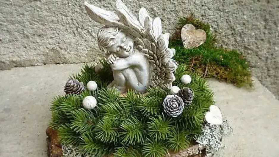 Malé světlo vzpomínek uprostřed dekorace na hrob Malé světlo vzpomínek uprostřed dekorace na hrob