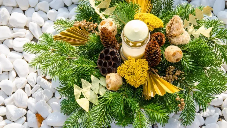 Malé světlo vzpomínek uprostřed dekorace na hrob Malé světlo vzpomínek uprostřed dekorace na hrob